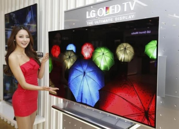 A model poses next to LG Electronics' organic light-emitting diode (OLED) television in Seoul January 2, 2013. REUTERS/Lee Jae-Won