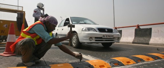 NEW DELHI, INDIA ? AUGUST 1: Workers install a metallic speed breaker on the Dwarka flyover after 9 people lost their lives on the flyover due to the faulty design of the flyover in New Delhi on Saturday, August 1, 2009. (Photo by Shekhar Yadav/ India Today Group/ Getty Images)