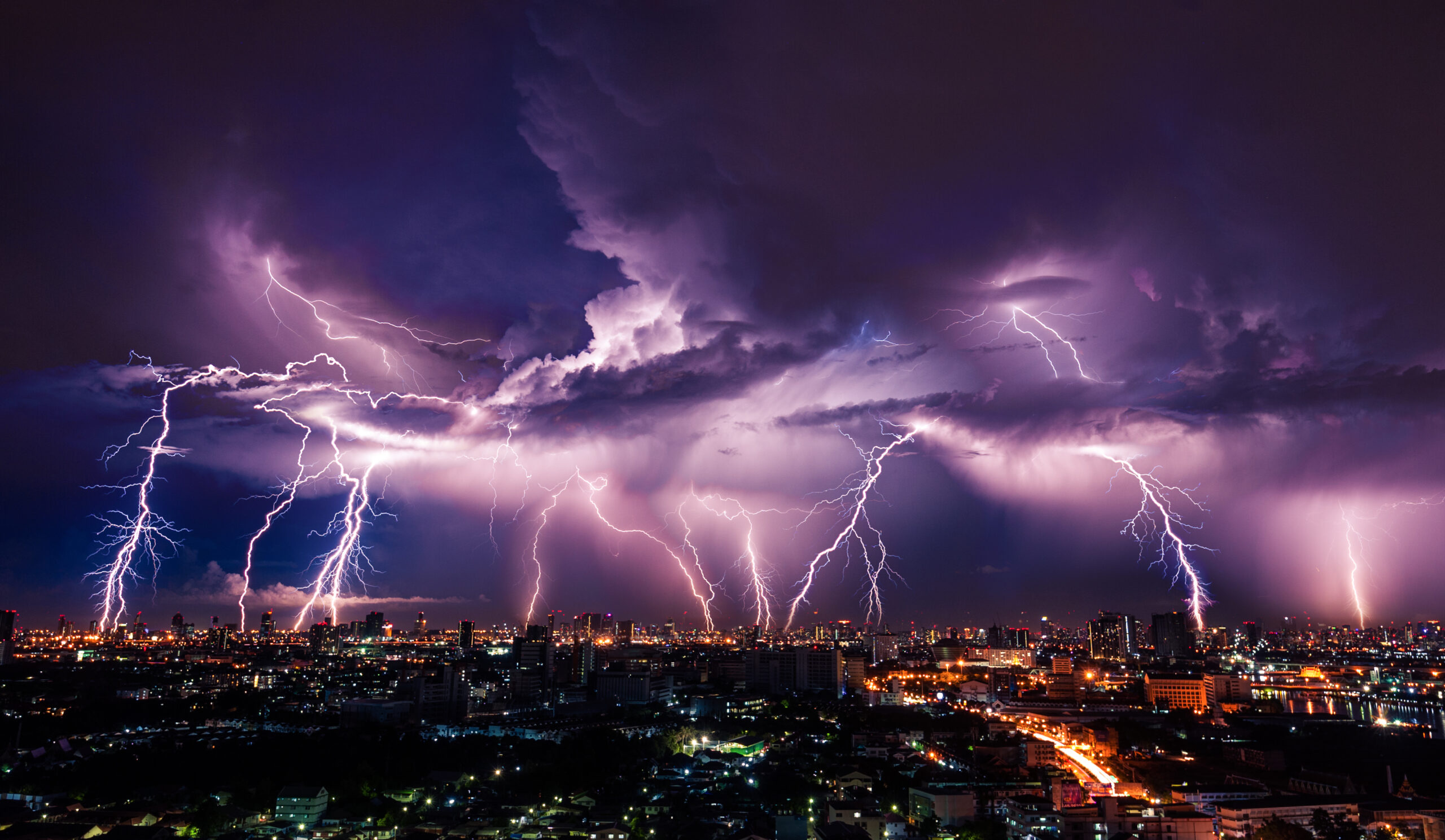 Lightning storm over city in purple light - TeknoTalk.