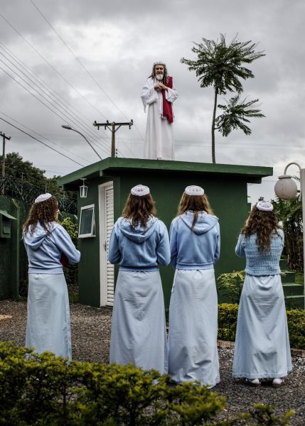 Brazil. 2014. Brasilia.<br /> INRI Cristo leading a liturgy from the top of the guardhouse, which they sometimes use as a pulpit.<br /> INRI (born Alvaro Theiss) takes his rst name from the initials of the inscription the Romans placed on the cross to spite him 2,000 years ago: Iesus Nazarenus Rex Iudaeorum, or Jesus of Nazareth, King of the Jews. The first awaking as the Christ came already in 1979 during a fast in Santiago of Chile, and INRI subsequently spent many years as a wandering preacher before settling in New Jerusalem, which is located outside of Brasilia.<br /> Most of the dozen or so disciples who live inside INRI’s compound are women. While the 69-year old Saviour and his followers live a private and secluded life, they are also busy disseminating his teachings to the world via the Internet, using YouTube, music videos and live broadcasts of sermons. From the book “The Last Testament”.