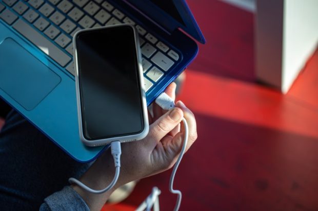 A smartphone connected to a laptop using a USB cable, phone charging, data exchange. Sanal Mobil Test Cihazlarının Sağladığı 4 Fayda
